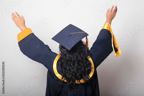 Foto Young, dark-haired Latina woman dressed in a cap and gown is happy and excited t