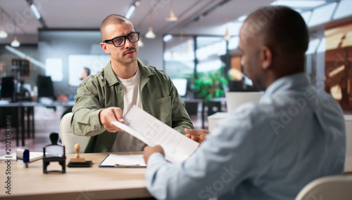 Foto Young Man In Office Stamping Important Property Document