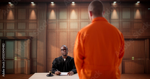 Φωτογραφία Man In Orange Jacket Stands
