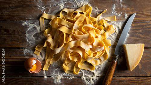 Принти на полотні Homemade fresh tagliatelle pasta with flour egg and parmesan cheese on wood