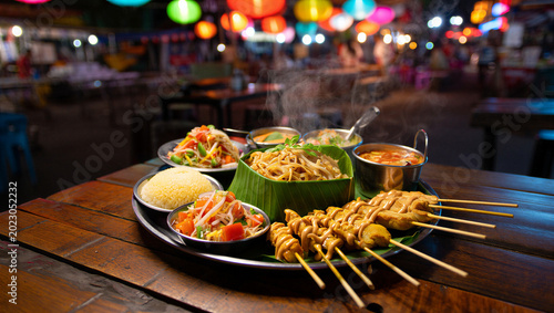 Tableau sur toile Authentic thai street food platter with satay skewers noodles papaya, asian food