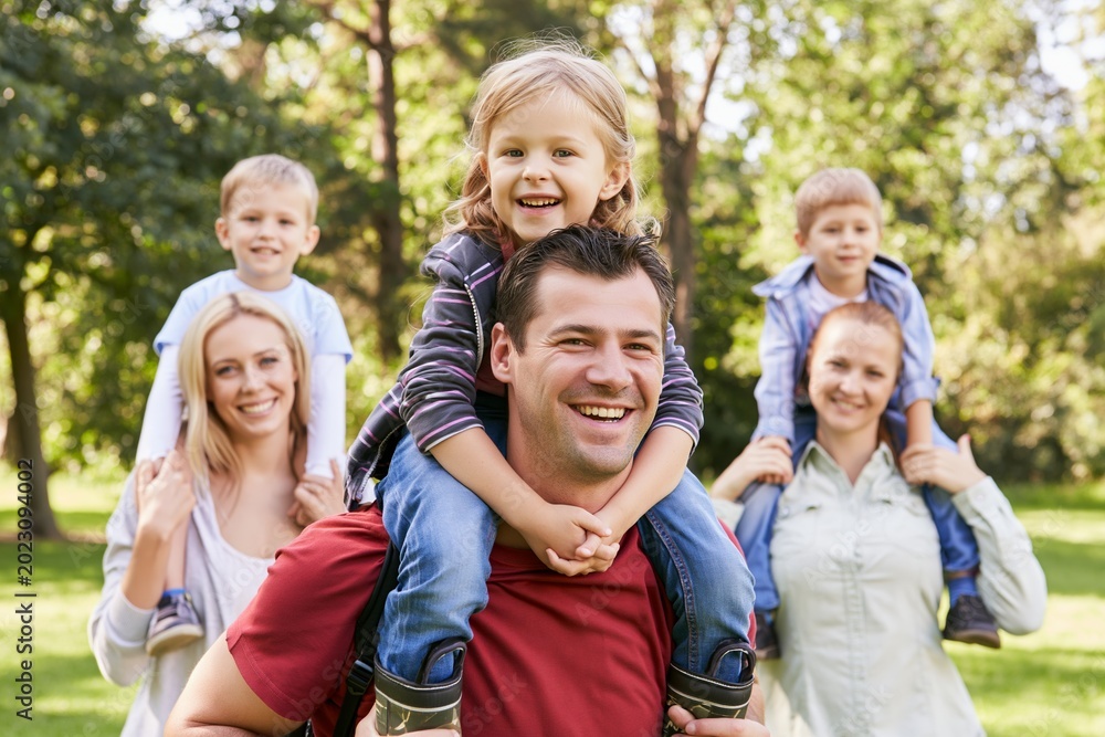 Fototapeta premium Cheerful parents and children spending day in park