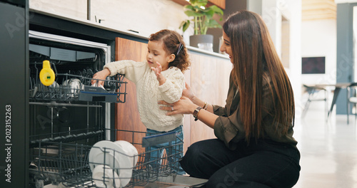 Foto Child, helping and mother with dishes in kitchen for hygiene, teaching cleanliness and guidance