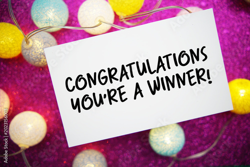 Congratulations You're a Winner! text written on paper card with LED cotton balls decoration