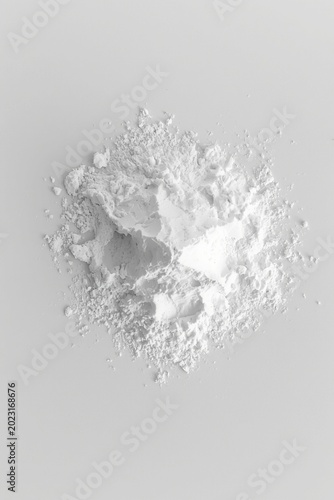Top view of pure white cosmetic powder pile on abstract background