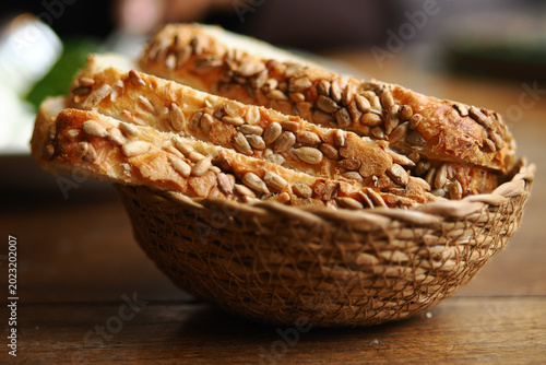 Foto Bread sticks with seeds in a woven basket on a table