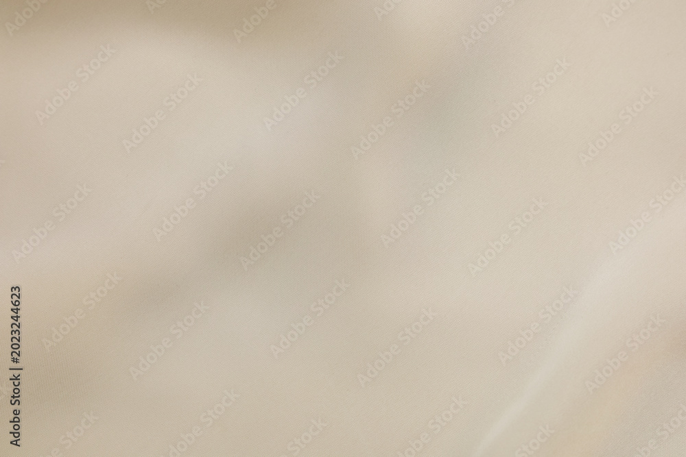 Obraz premium Elegant beige silk fabric texture background with soft folds and smooth luxury textile waves