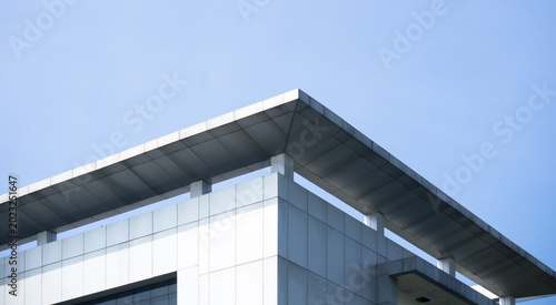 Bild auf Leinwand Low angle view of a modern office building exterior with silver metallic claddin
