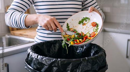 Person Scraping Food Waste into Bin Kitchen