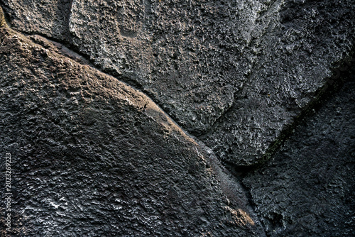 Fotografie close up of a dark grey rough concrete wall texture with organic grainy patterns