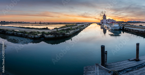 Foto windmill in the salt flats at sunset, Stagnone Nature Reserve, Marsala , Trapani
