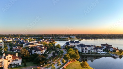 Aerial view of luxury houses in Houston, Woodlands by the lake with dramatic cloudy sky in Texas, United States