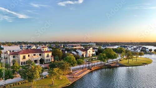 Aerial view of luxury houses in Houston, Woodlands by the lake with dramatic cloudy sky in Texas, United States