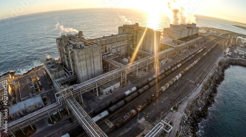 Aerial view of industrial complex with rail infrastructure on coastline