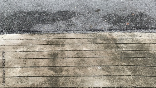 Tableau sur toile Close-up of asphalt and concrete curb junction showing surface wear, stains, and
