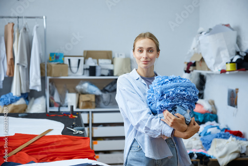 Young artist cataloging colorful fabric swatches efficiently