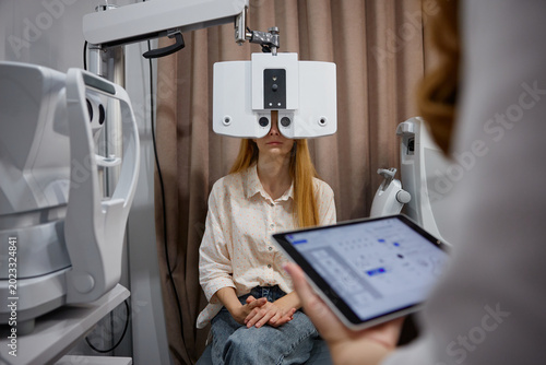 Female patient having detailed eye checkup. Young woman receiving thorough visual evaluation