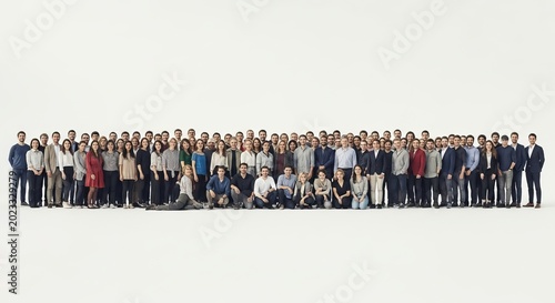 A large, diverse group of people posing together in a studio setting, showcasing unity and collaboration for a professional photograph.