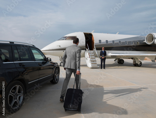 Tableau sur toile Middle Eastern business team boarding private jet for executive travel at desert