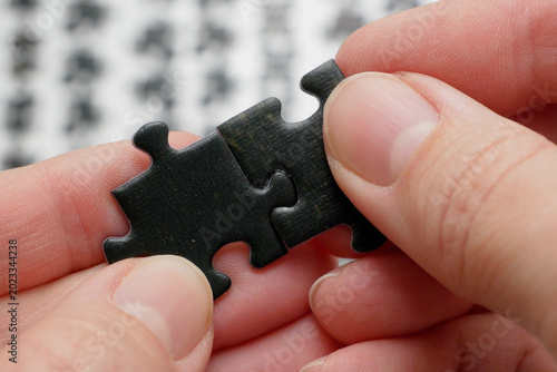 hands putting together a puzzle on white background, method for collecting puzzles by sorting
