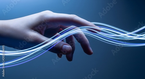 Close-up of a human hand touching glowing blue fiber optic light trails representing digital connectivity and high-speed data transfer.
