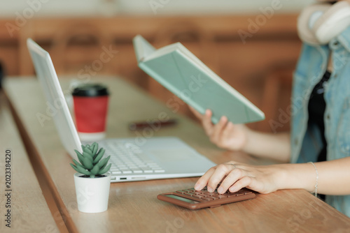 Professional freelancer multitasking with a calculator, laptop, and stationery, visualizing efficient business management.