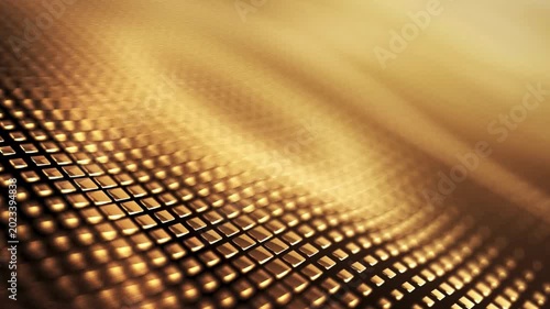 Close up of shimmering golden textured surface with small squares flowing like water waves in subtle motion and soft light, elegant background.