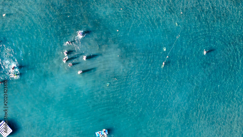 Canvas Print Vibrant summer day with sunbathers and swimmers enjoying crystal-clear water in