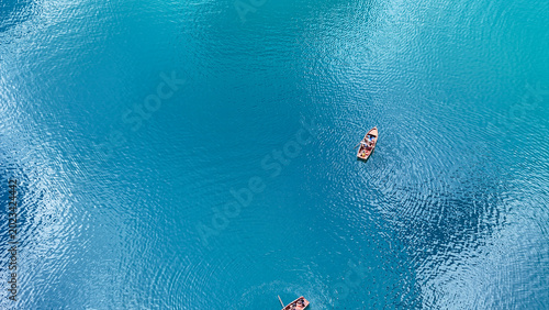 Фотография Serenity blooms on azure waters as kayakers glide gracefully under the midday su