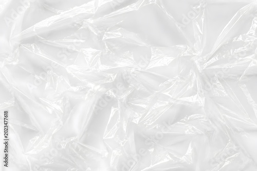 wrinkled transparent plastic bag texture top down close up minimalist photography soft natural light white background subtle shadows
