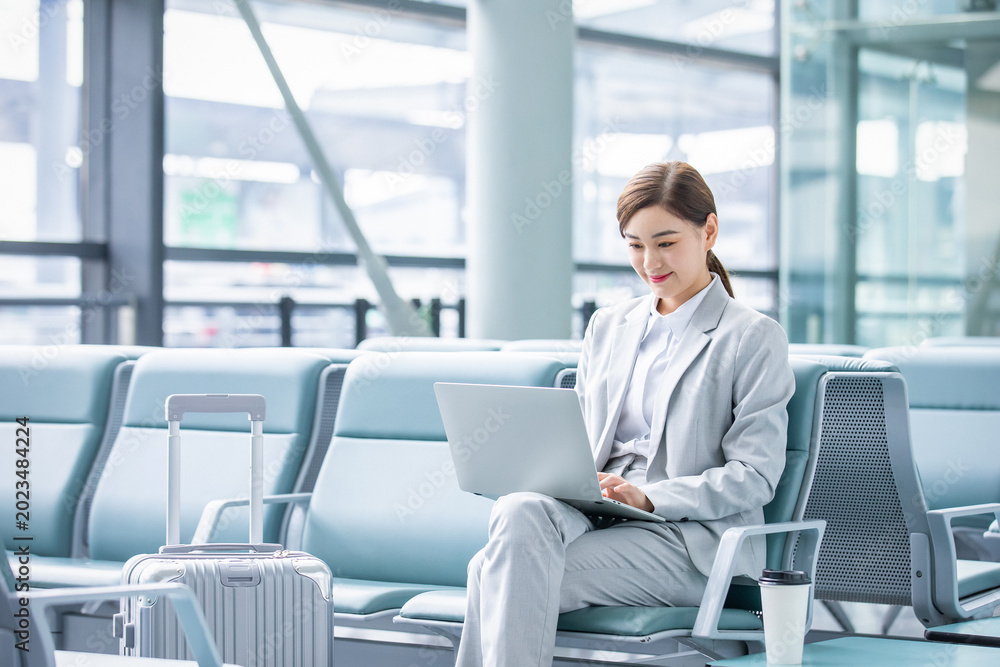 Fototapeta premium Businesswoman Working on Laptop in Airport Lounge