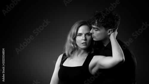 Obraz na płótnie Young man kissing woman's neck, focusing on love, connection, and tenderness