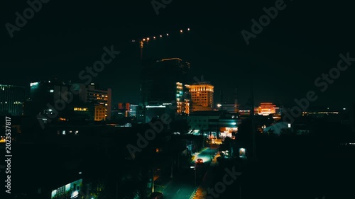 Vibrant Commercial District at Night with Construction Crane – Aerial View of Southeast Asian City