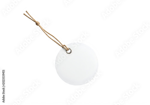 Round white paper tag with brown string and metal eyelet isolated on a transparent background