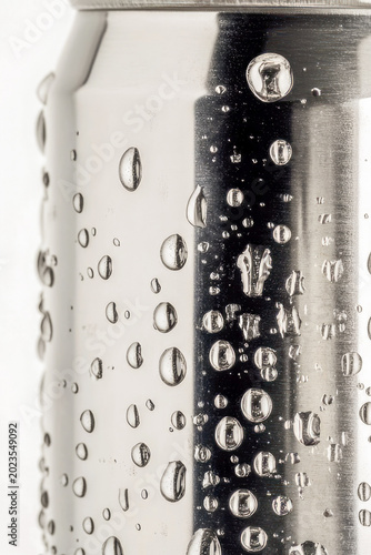 A can of soda sits atop a table. vertical frame
