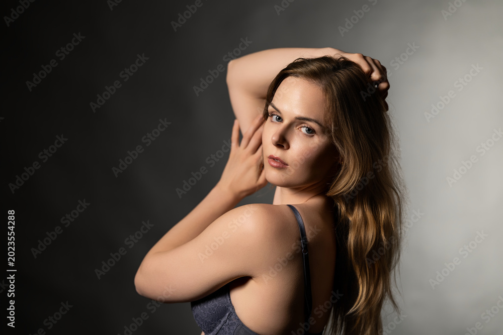 Fototapeta premium Woman posing in blue lace lingerie, looking at camera with sensual expression