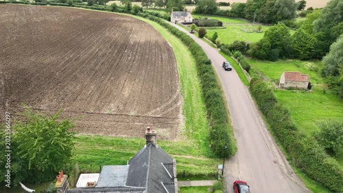 Aerial View of Rural Country Road and Stone Cottage Through Northamptonshire Farmland England