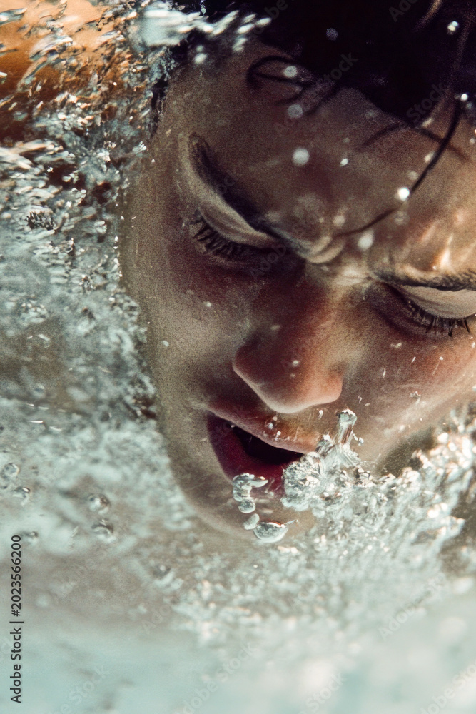 Fototapeta premium A person swimming in a pool, surrounded by calm water and perhaps some pool toys or decorations. vertical frame