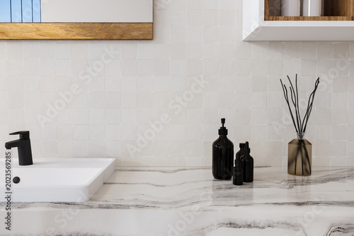 Fotografie Close up modern bathroom vanity with sink, black faucet, marble countertop and tiled wall in soft natural light