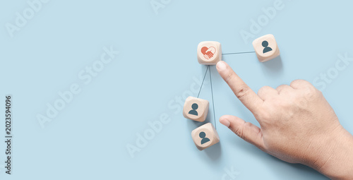 Obraz na plátně Hand pointing wood cube with empathy leadership icon