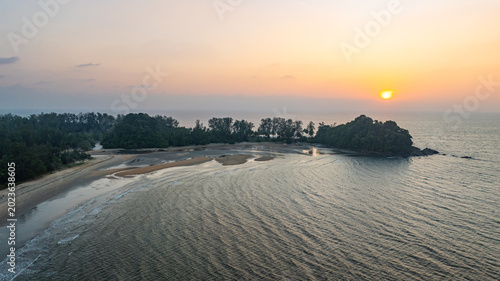 Fotografie A stunning aerial view of a peaceful coastal island at sunset, with golden hues reflecting on the calm ocean waters