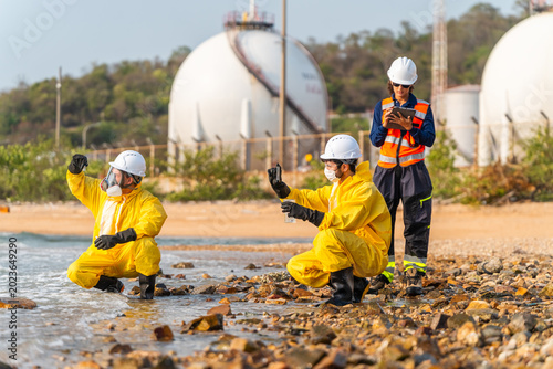 Photos Corporate ESG and CSR sustainability: Hazmat scientists and ecologist testing toxic ocean water pollution near petrochemical refinery storage tanks for industrial environmental hazard control