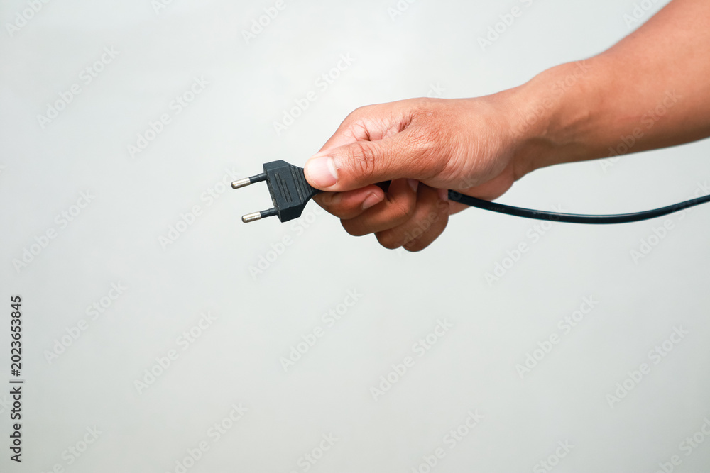 Fototapeta premium Hand holding electric plug ready to connect power source