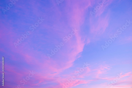 Blue sky and pink clouds. Cirrus clouds at sunset. Delicate natural pink and blue background, wallpaper.