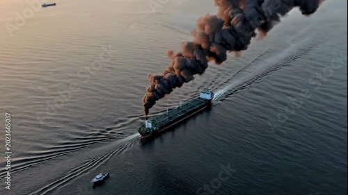 A video of a cargo ship on fire in the ocean during sunset