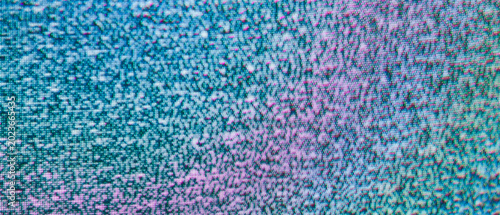 Colorful tv static on a crt screen with teal to pink color gradient macro shot