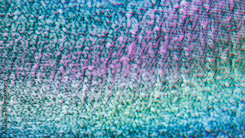 Close-up of pink and teal tv static noise on retro crt screen texture background