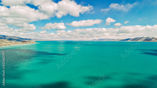 Foto Drone view of turquoise Bear Lake with cloud shadows and distant mountains in Ut