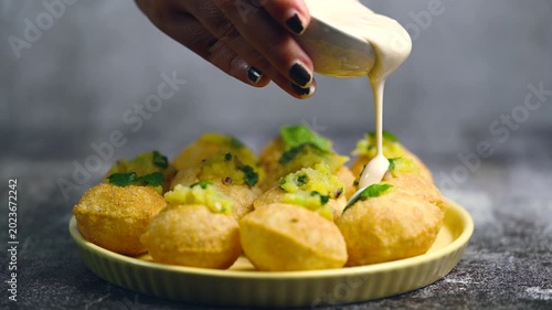 Close up of Indian street food fuchka on a plate glass with sour spicy water. Dahi Pani puri a chat item in India. 4K indian street food snacks.