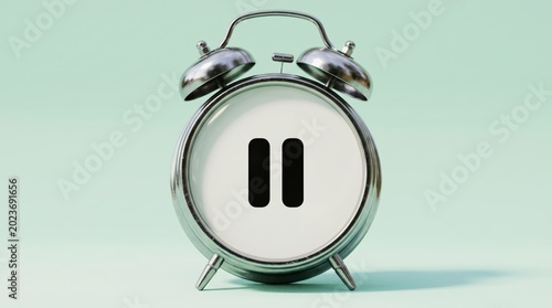 A silver alarm clock with a pause symbol on its white face